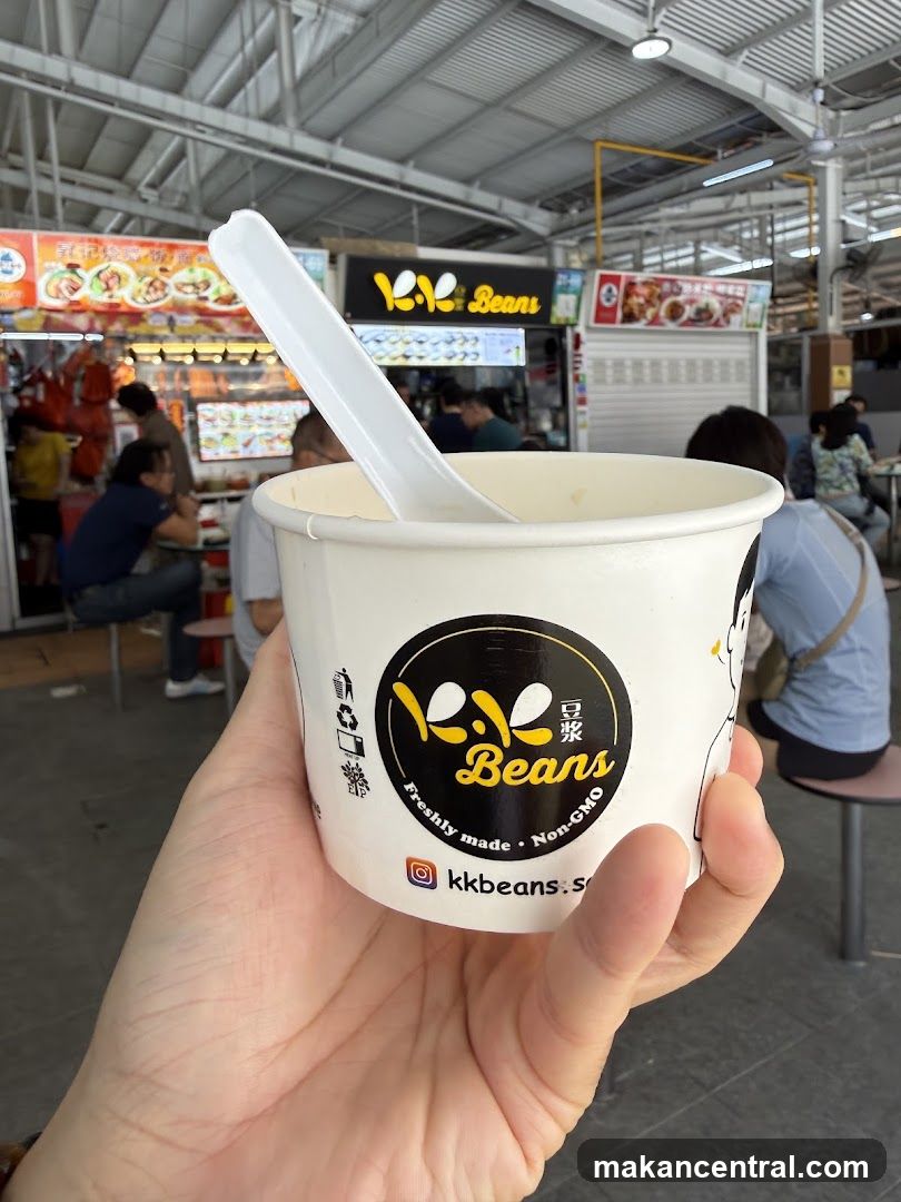 Hand holding a cup of bean curd from KK Beans stall