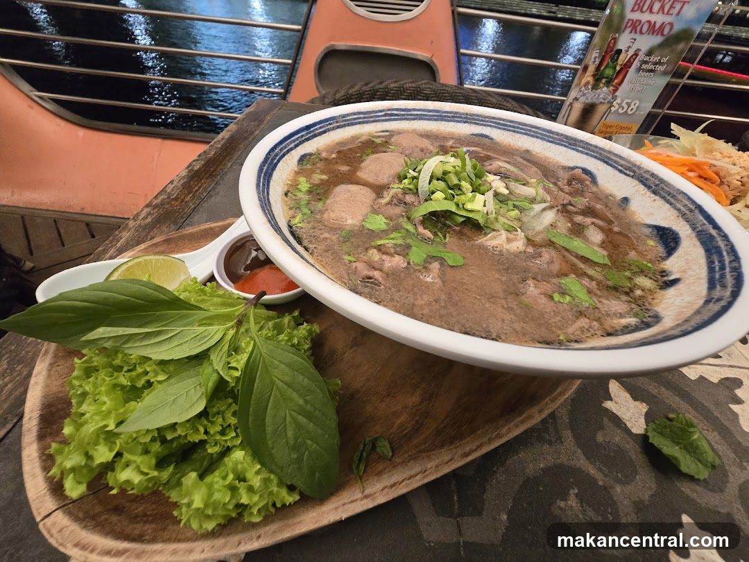 Pho dish on wooden tray with garnishes