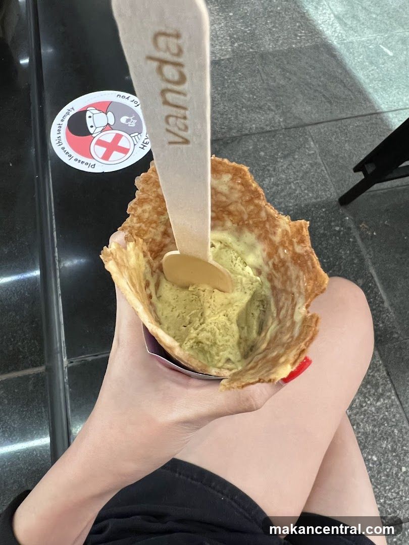 Hand holding ice cream in a wafer cone