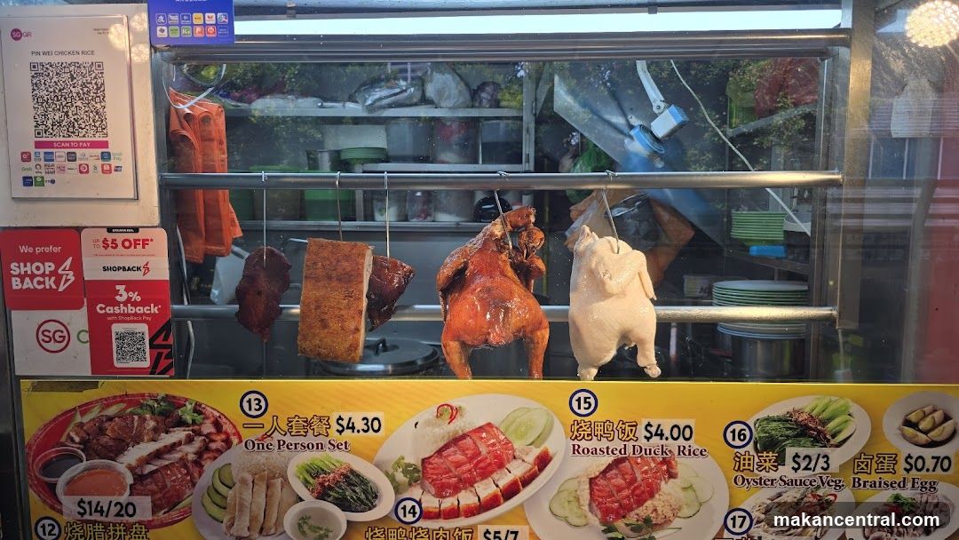 Food stall display with roasted meats and promotional posters