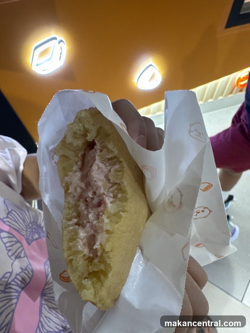 Hand holding a partially eaten pastry