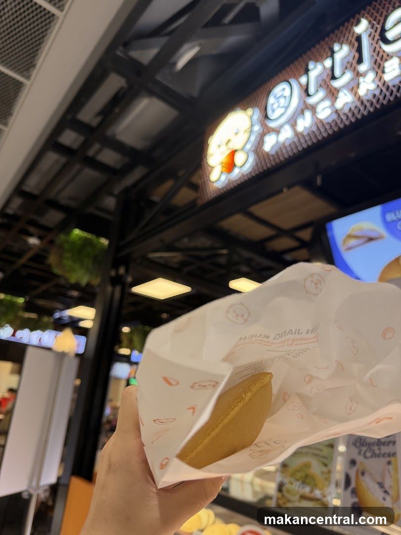 Hand holding food item in shopping mall