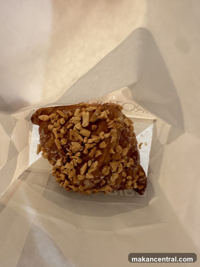 Peanut-topped pastry in paper wrapper