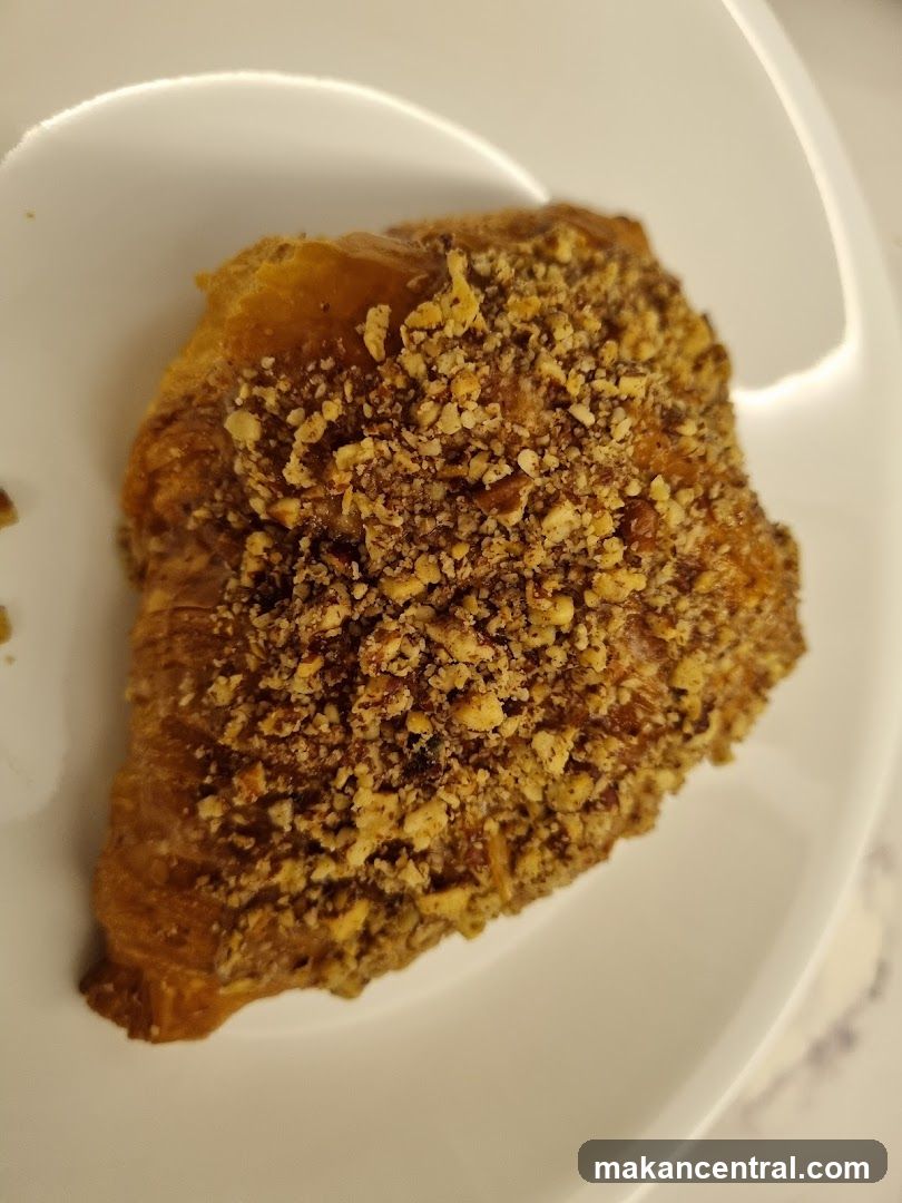 Nuts-topped pastry on white plate
