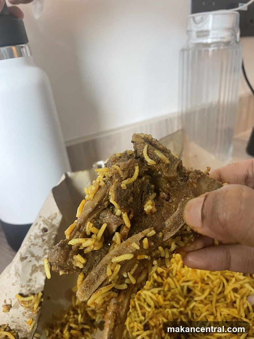 Hand holding biryani with meat