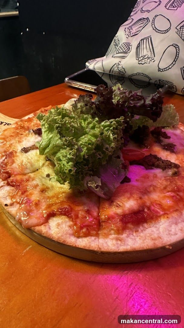 Pizza with lettuce on wooden table