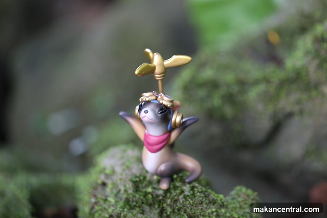 Otter figurine on mossy rock
