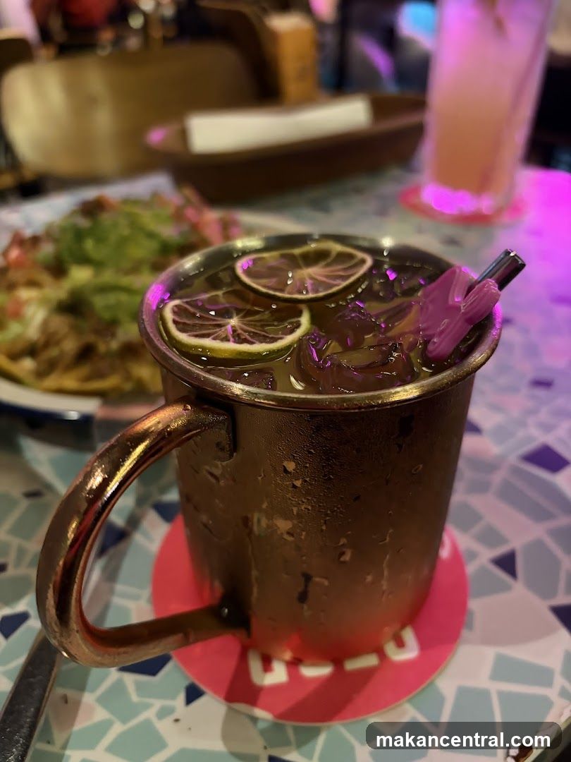 Copper mug drink with lime slices and purple straw