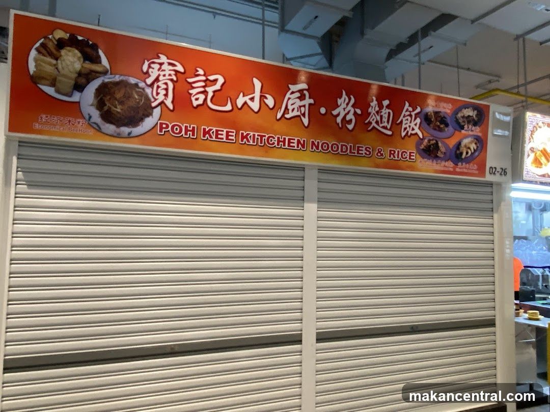 A closed storefront with a large orange sign above the metal roller shutter door. The sign displays Chinese characters "寶記小廚·粉麵飯" and English text "POH KEE KITCHEN NOODLES & RICE" along with images of food dishes. A small number "02-26" is visible on the right side of the sign.