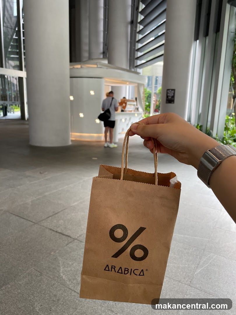 Hand holding % Arabica bag in modern interior