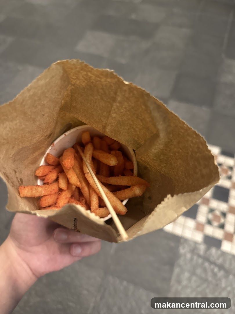 Hand holding fries in paper bag