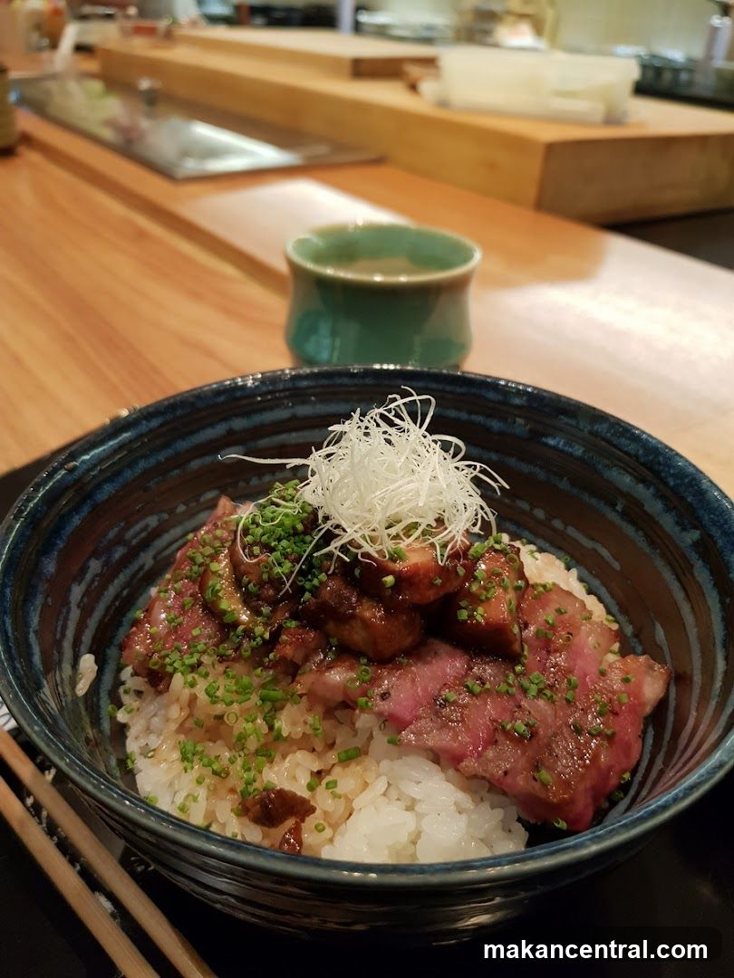 Bowl of rice dish with meat and garnish