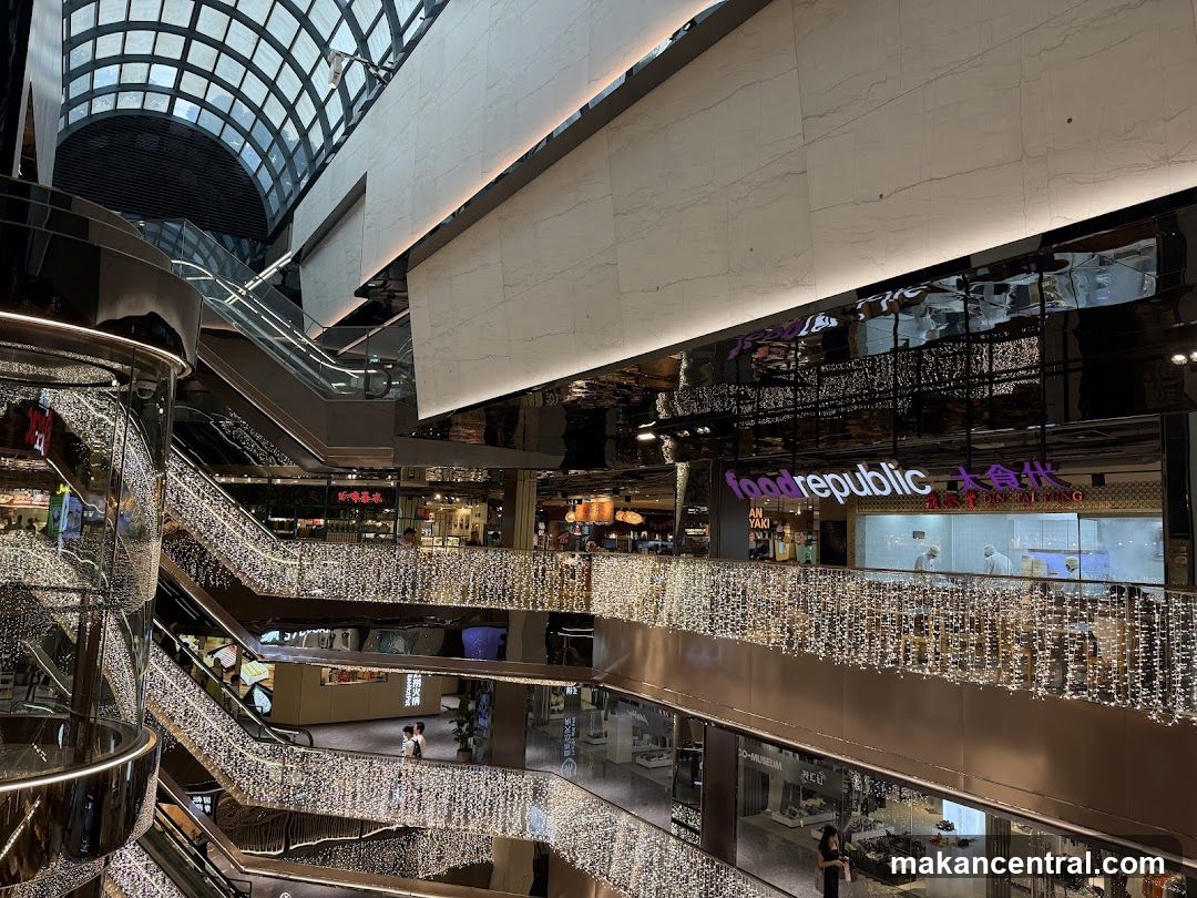 Interior of a modern shopping mall with escalators and festive lights