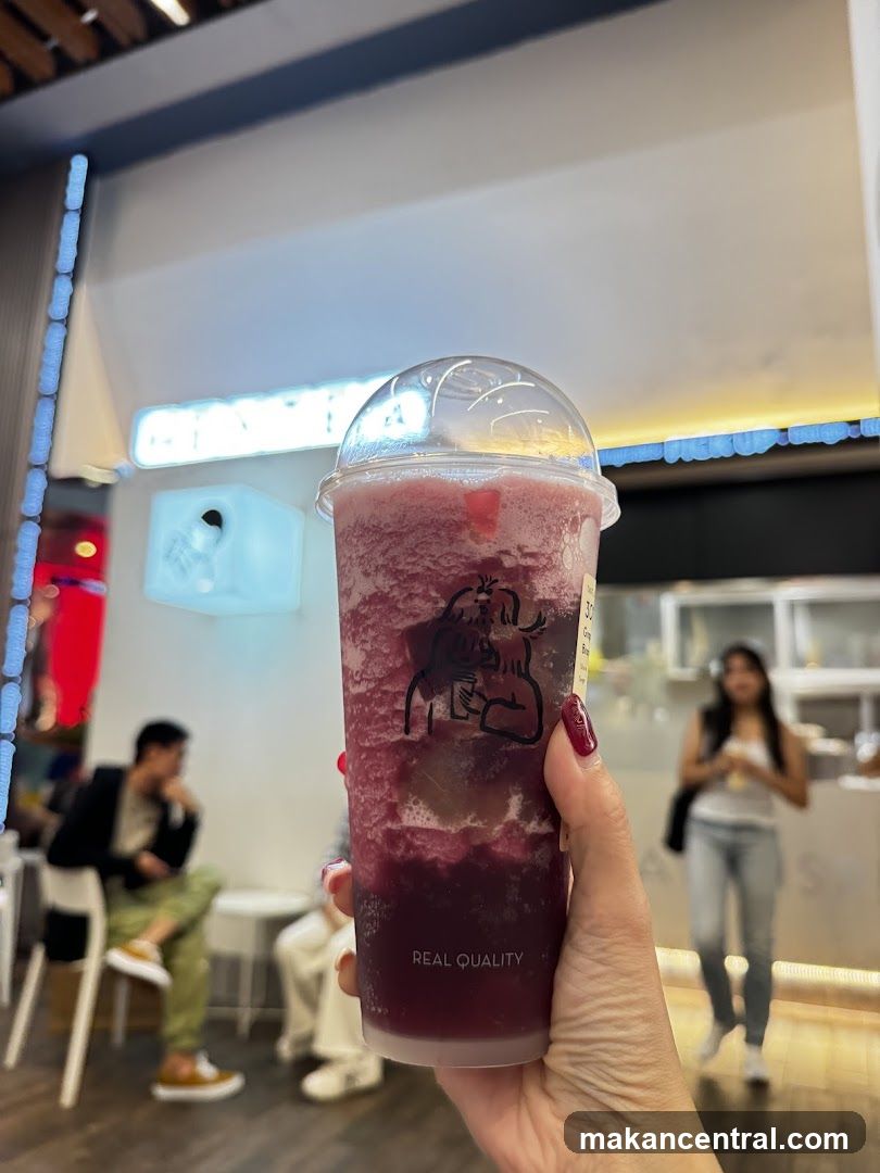 Person holding a berry smoothie
