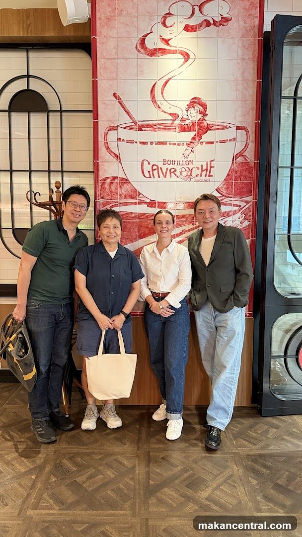 Four people posing in front of a tiled wall