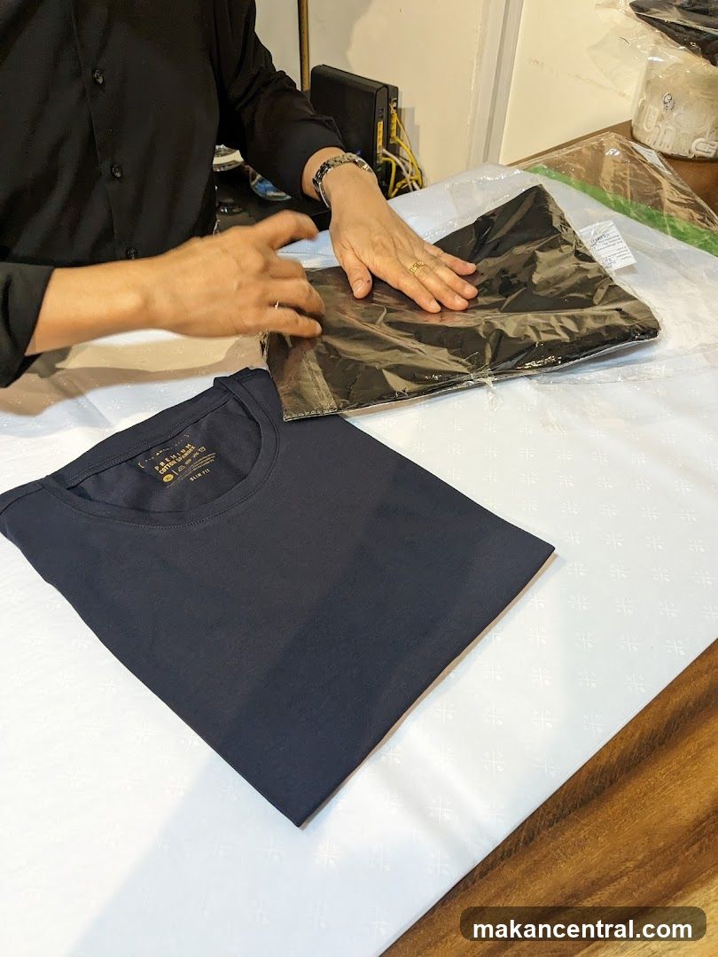 Person folding a black t-shirt