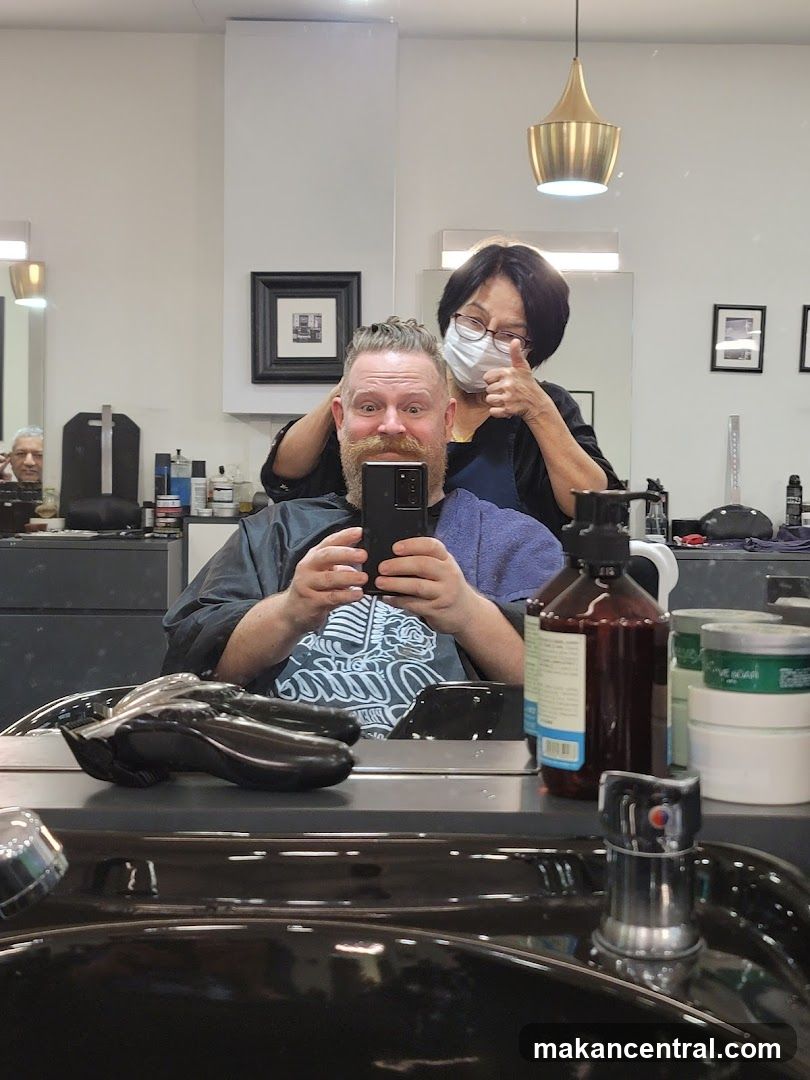 Barber giving a thumbs up while cutting hair