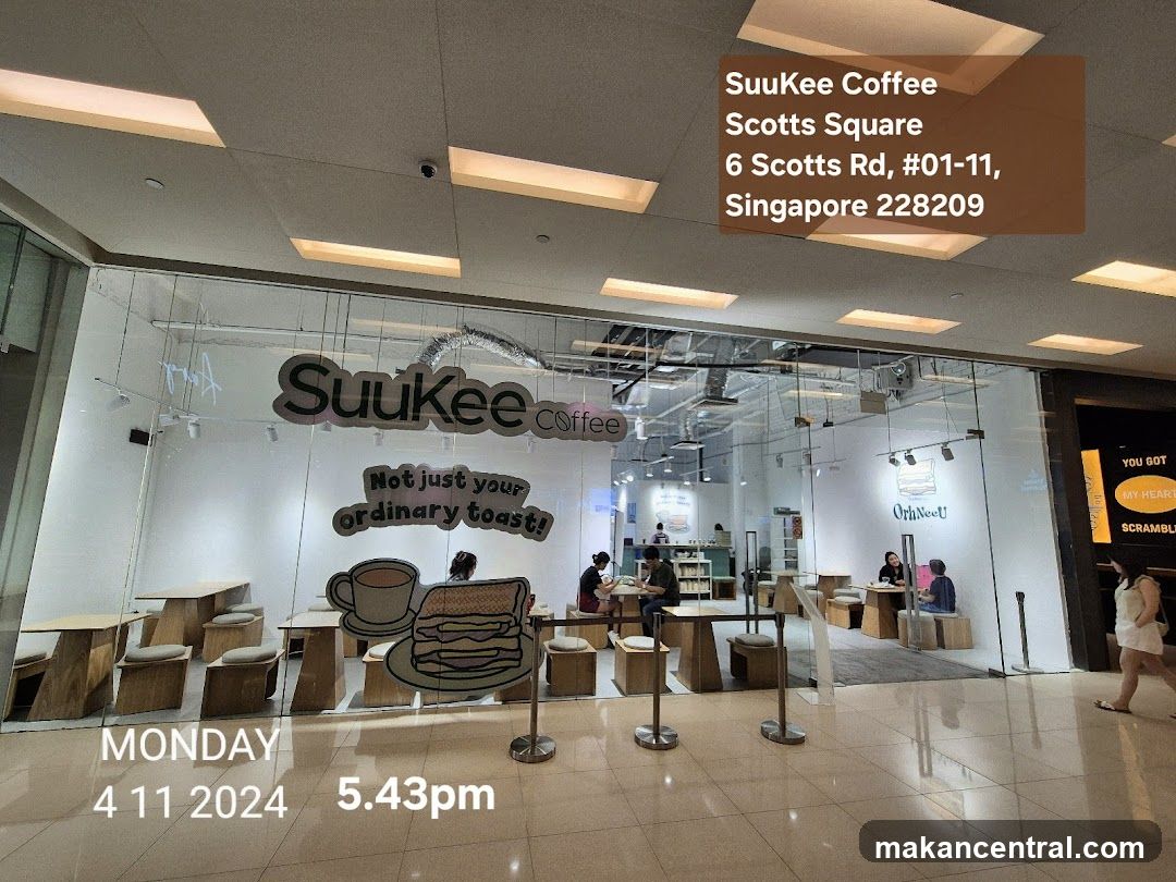 The exterior of a coffee shop with large glass windows. The shop's name,