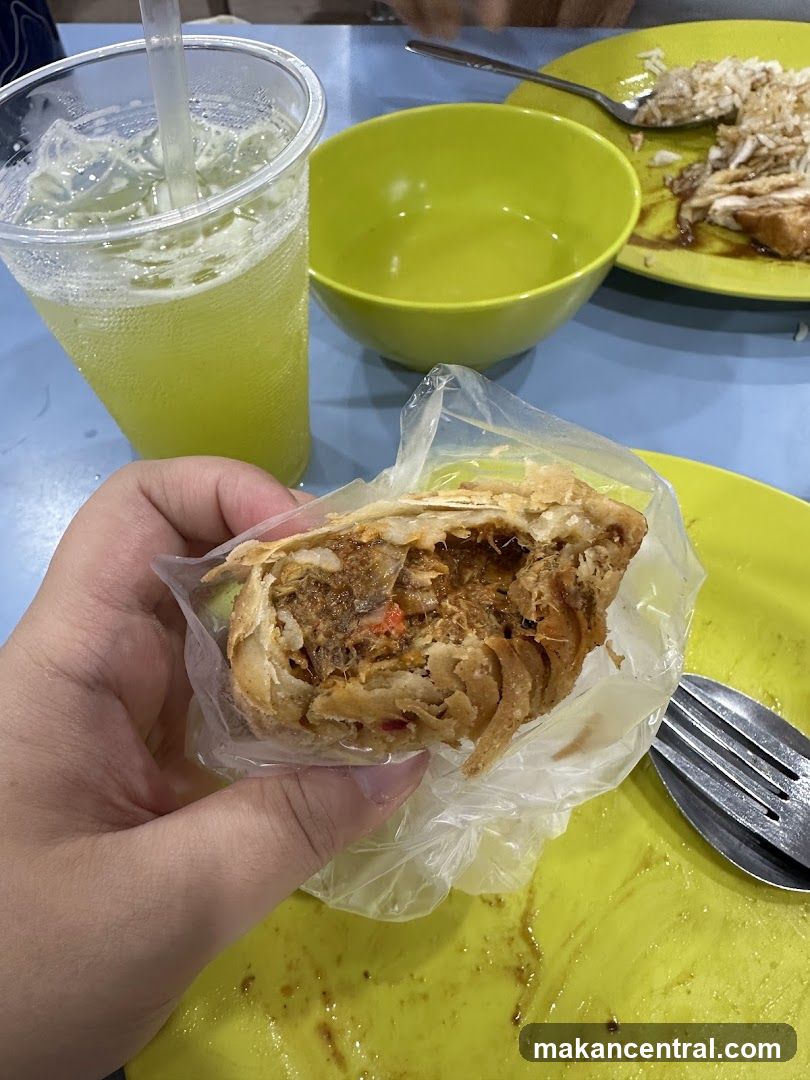 Hand holding a savory pastry with a drink
