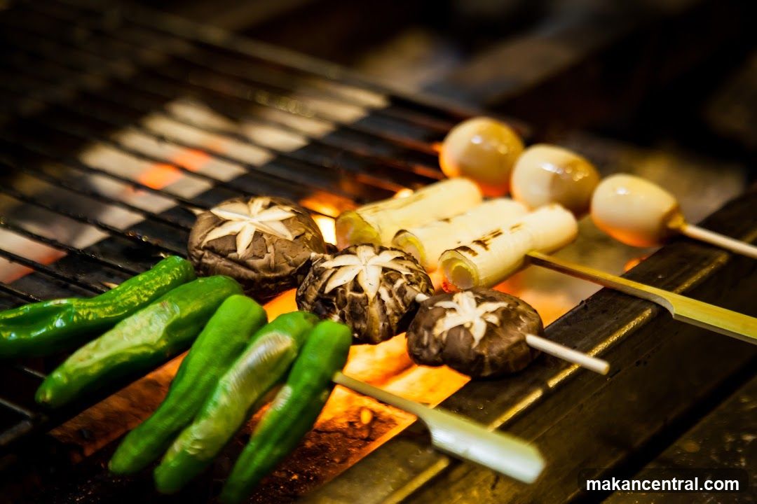 Skewers grilling over coals