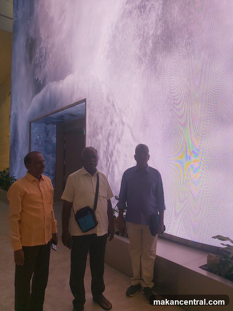 Three men standing in front of a large digital display
