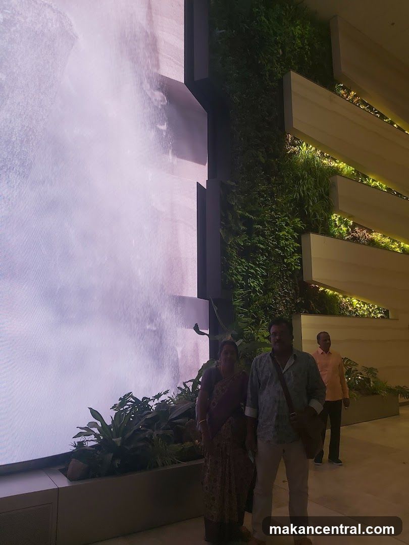 People in front of a large digital screen and a living wall