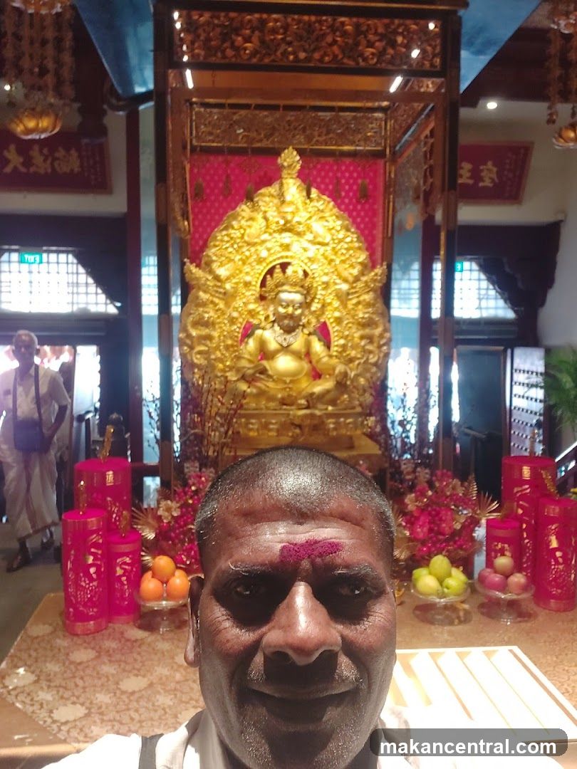 Man in front of a golden statue