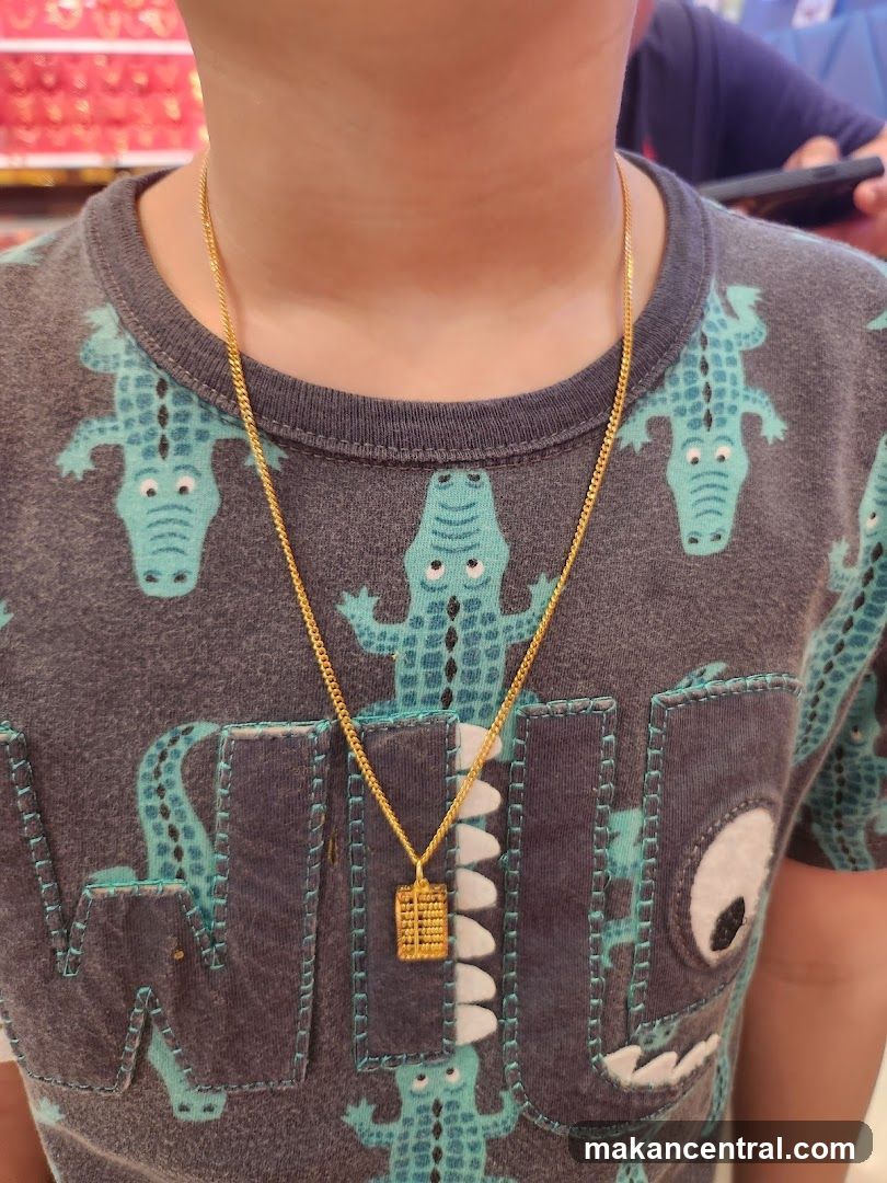 Child wearing a gold necklace with an abacus pendant