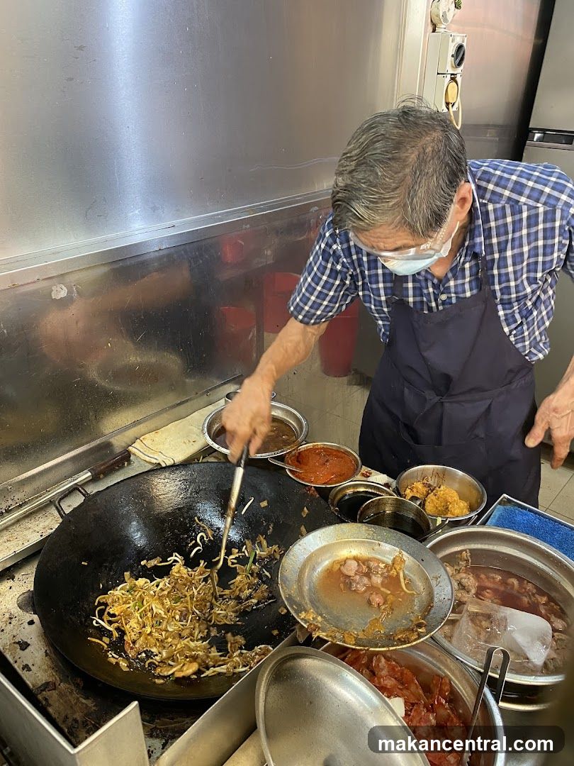 Chef cooking noodles in a wok