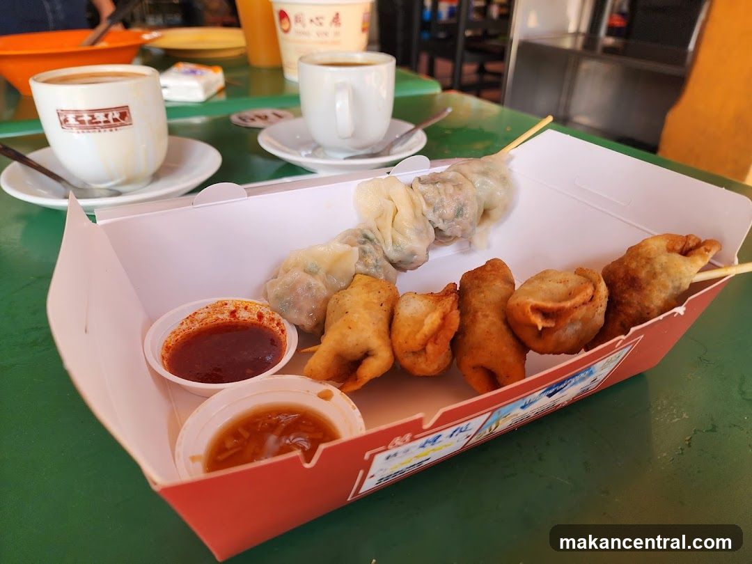 Skewers of dumplings and fried snacks with dipping sauces