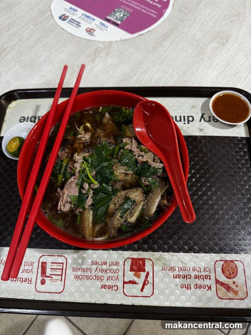 Bowl of noodles with chopsticks and spoon