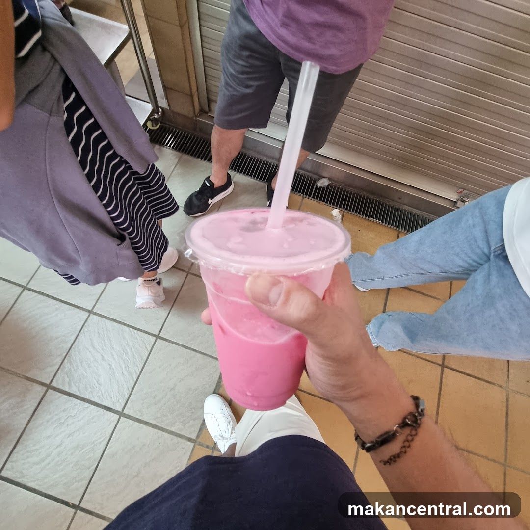 Person holding a pink drink