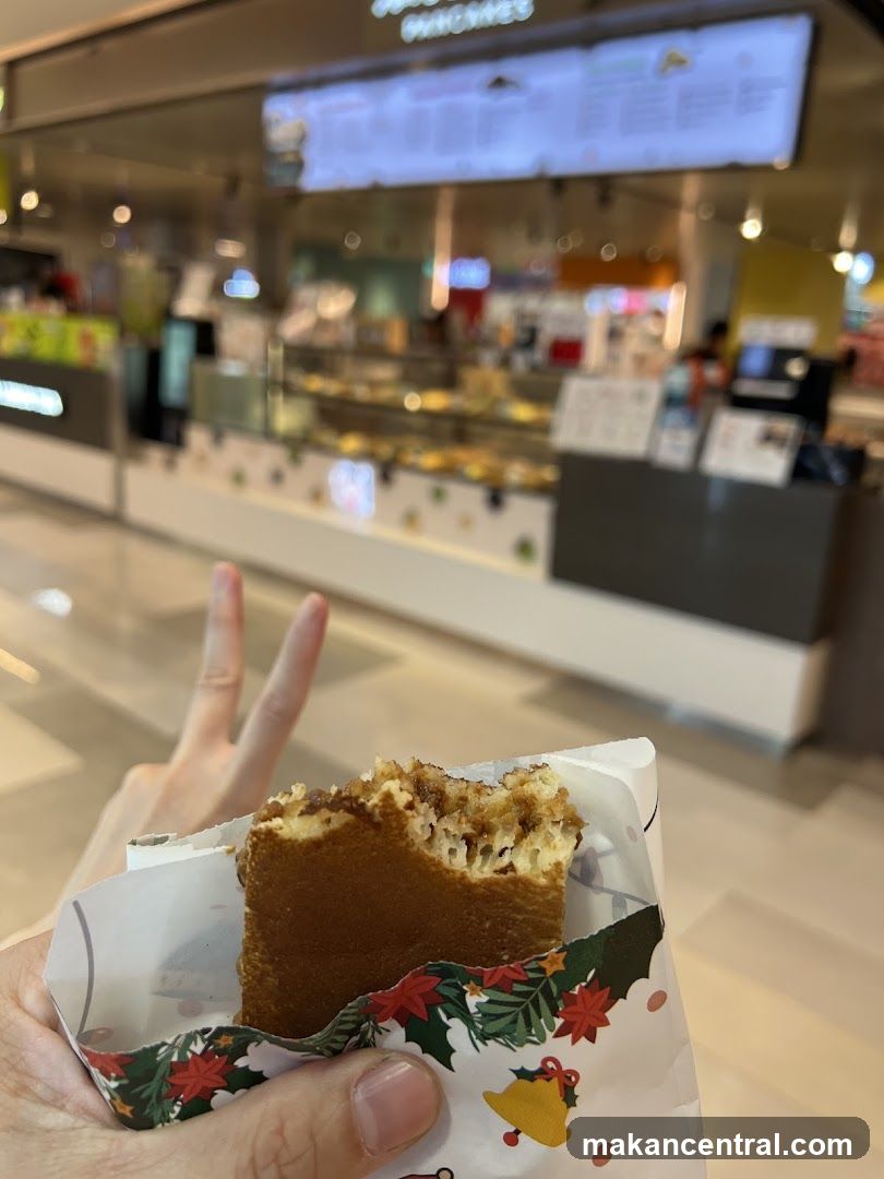 Person holding a snack with a blurred food stall in the background