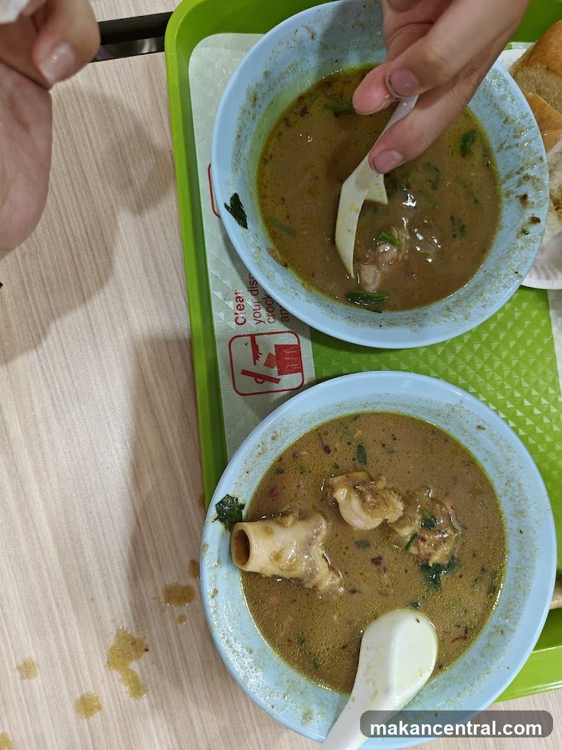 Two bowls of soup with meat and bones