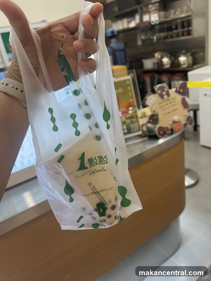 Person holding a bubble tea in a branded bag