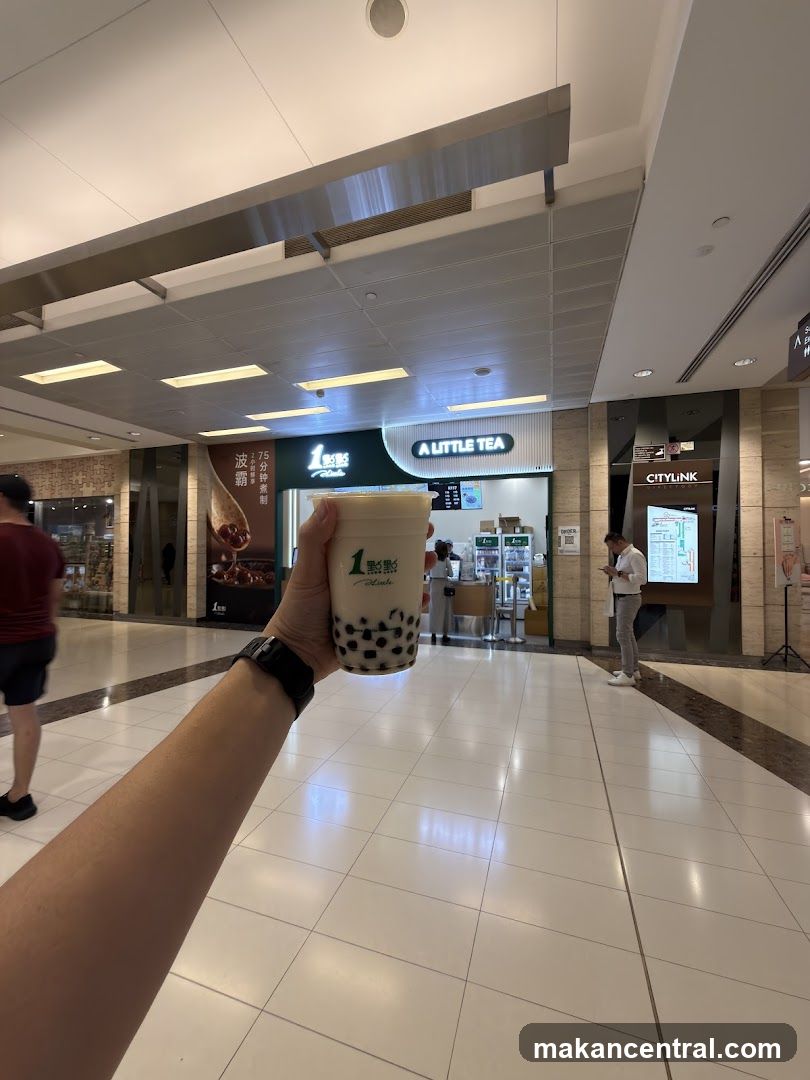 Person holding a bubble tea in front of a shop