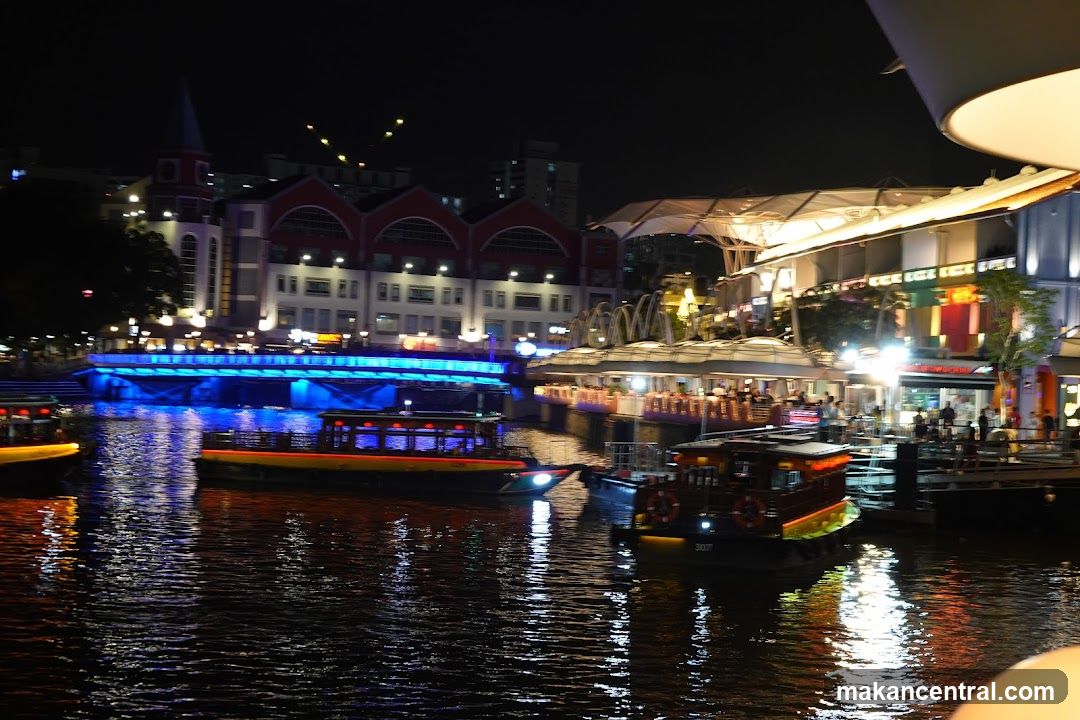 Nighttime Riverfront Scene with Boats and Buildings