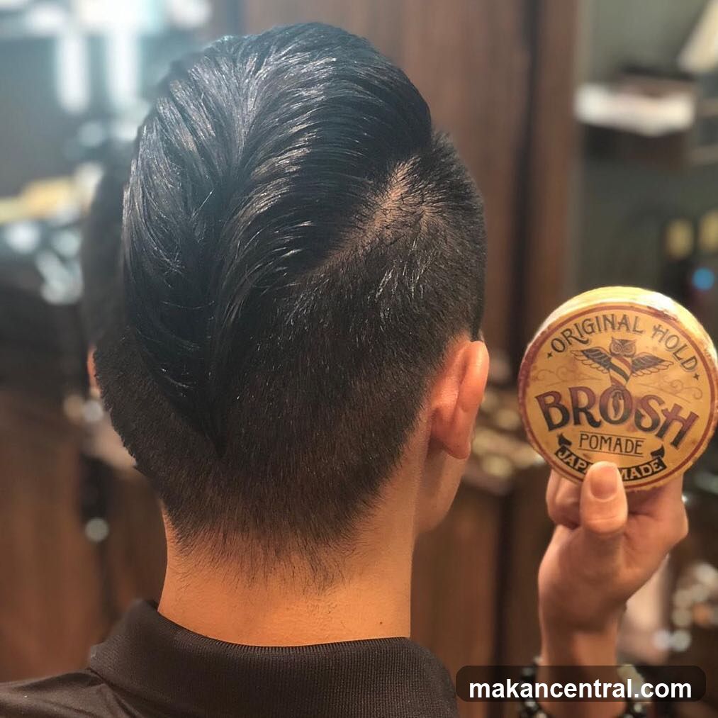 Man with styled hair holding pomade