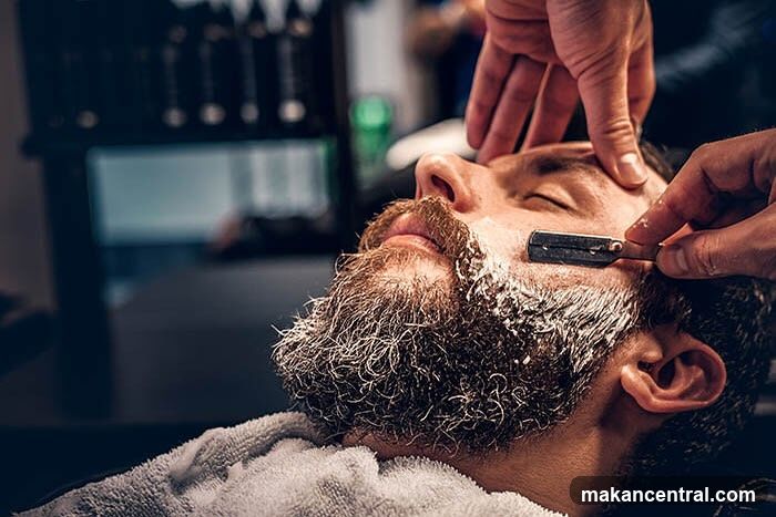 Barber shaving a man with a straight razor