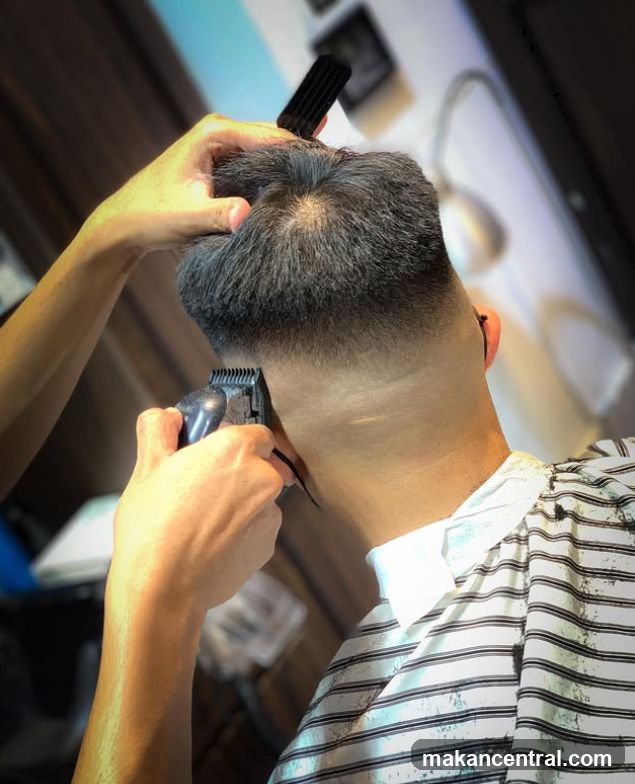 Barber trimming client's hair