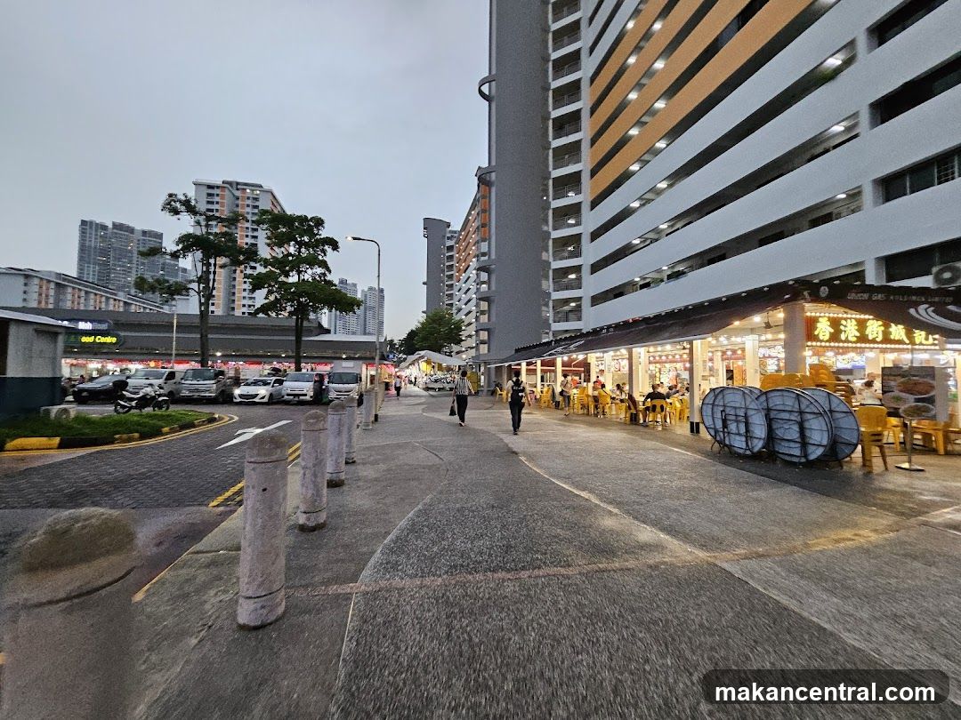Street scene with food stalls and apartment buildings