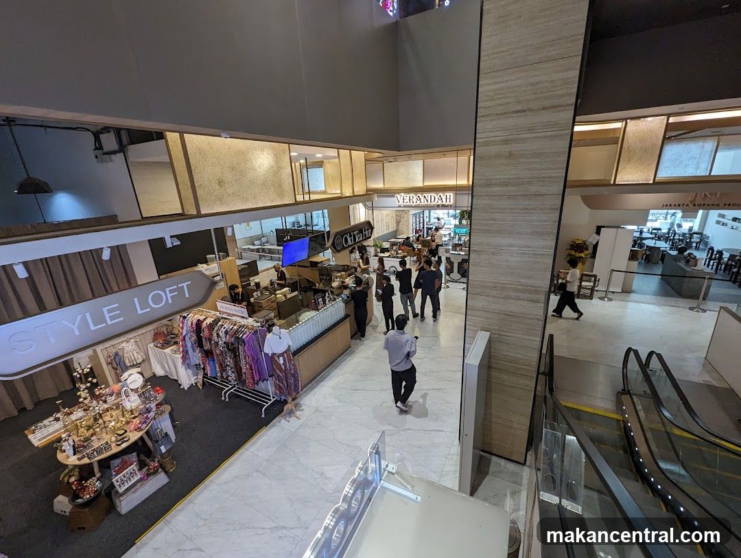 Interior of a shopping mall with various stores and escalators