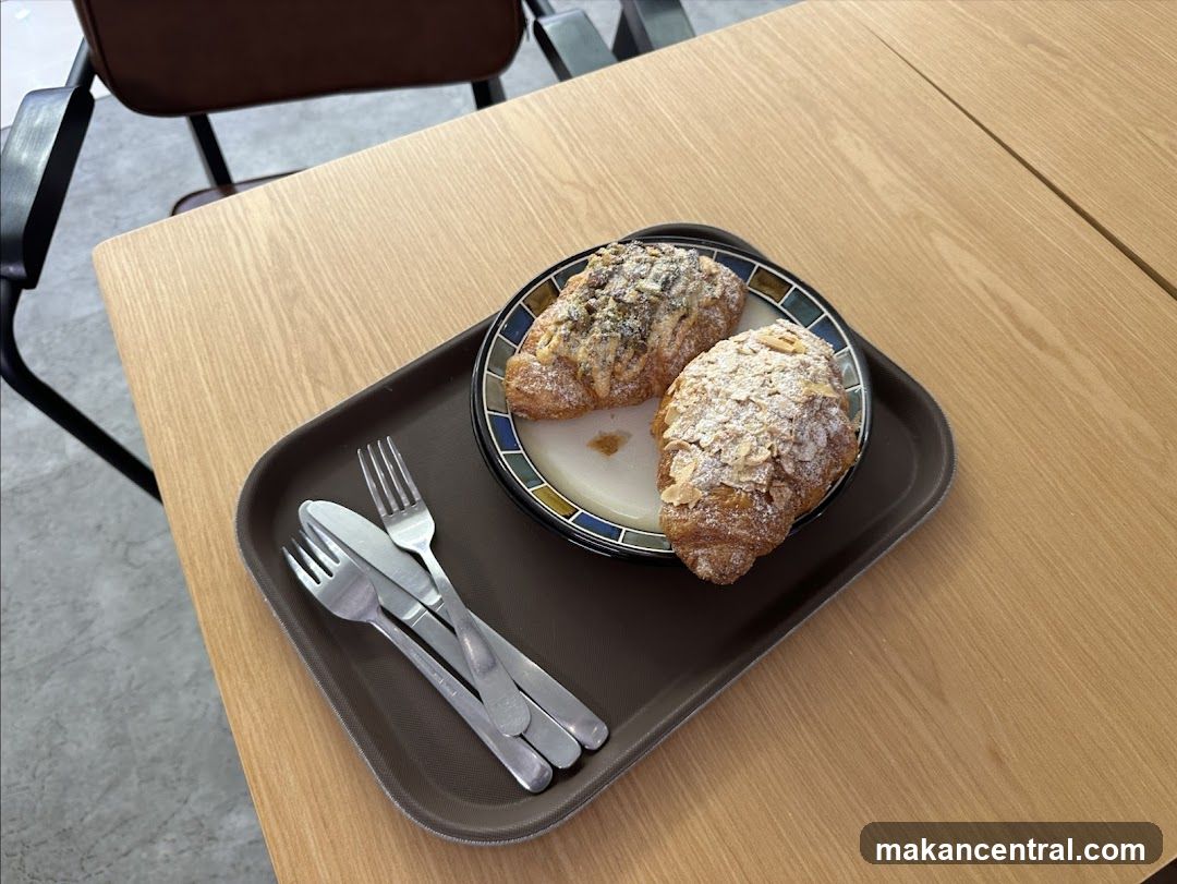 Two croissants on a tray with cutlery