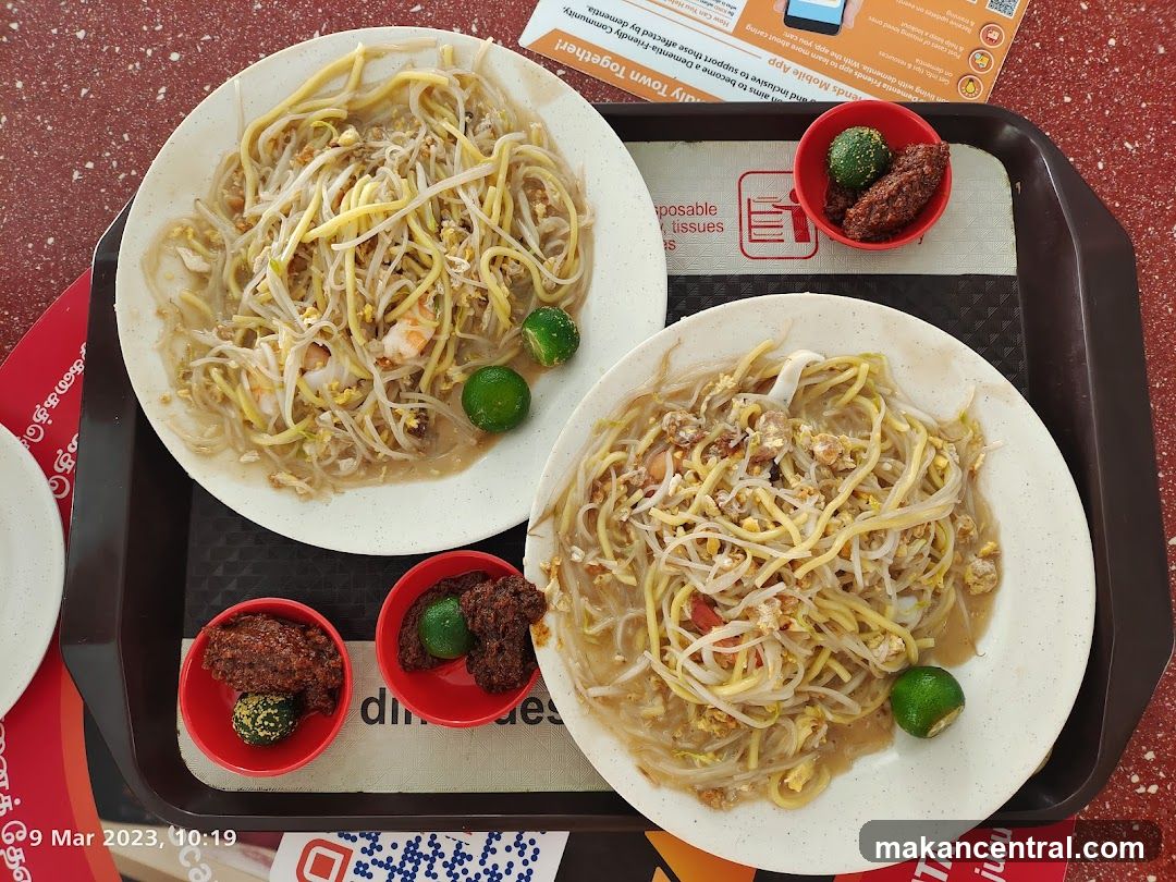 Two plates of noodles with chili and lime