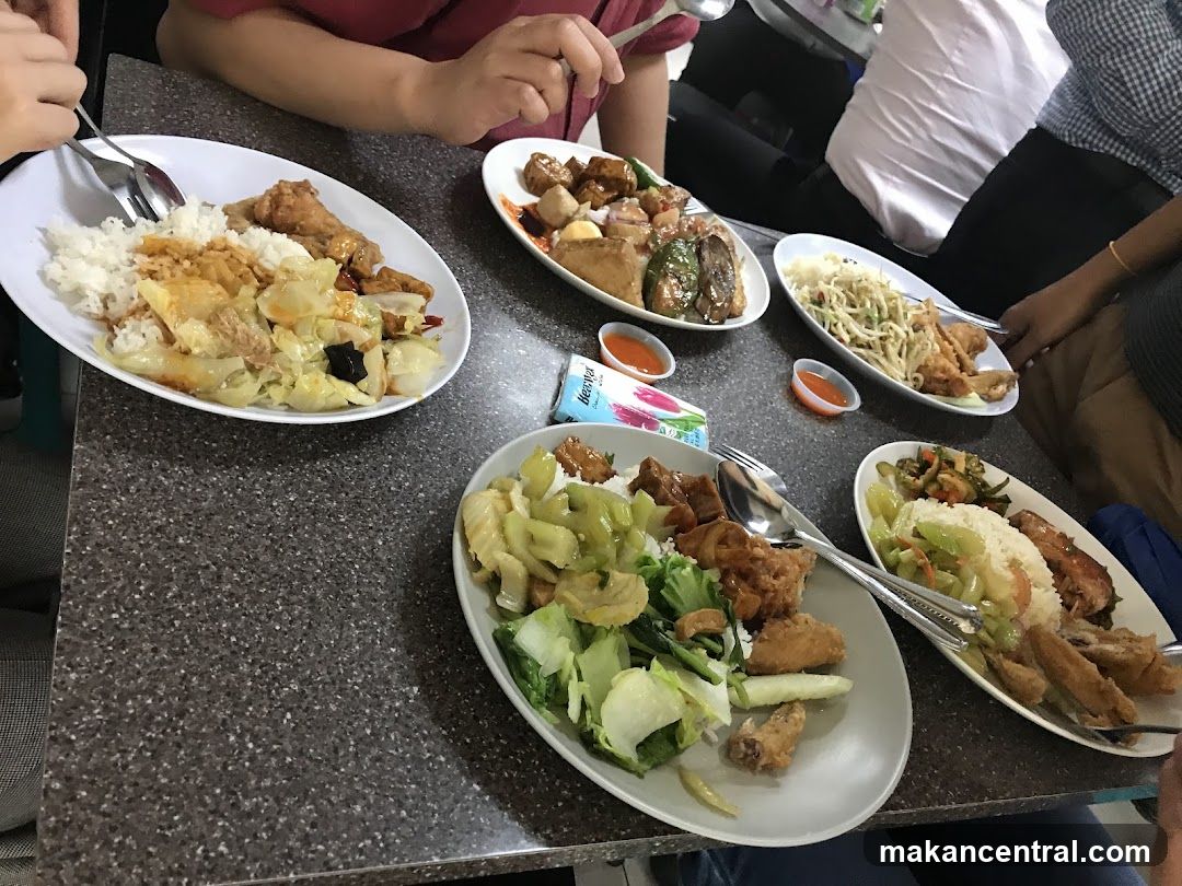 People eating at a table with several plates of food
