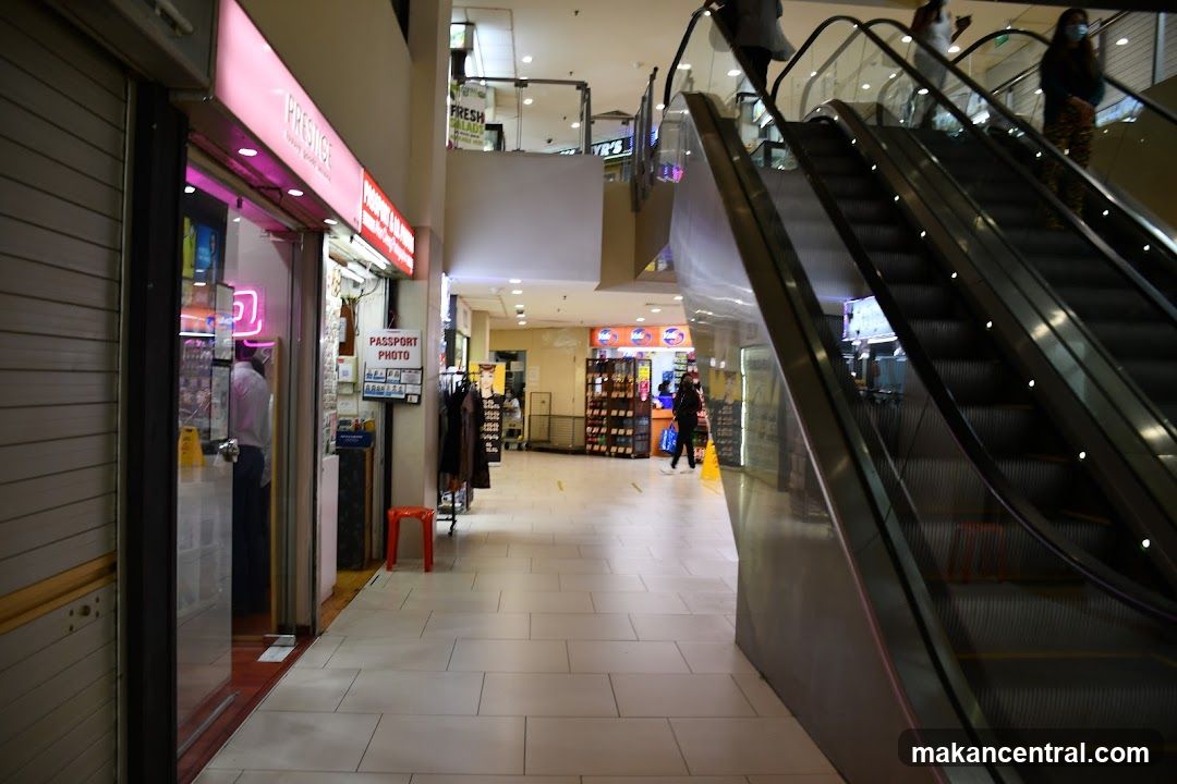 Indoor shopping mall corridor with escalators and shops