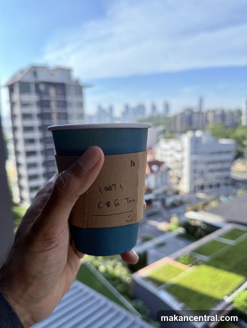 Hand holding a coffee cup with a view of a city skyline