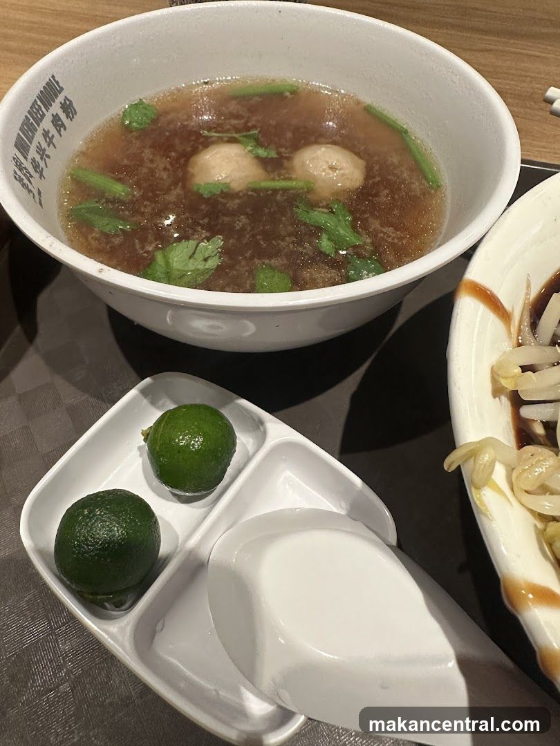 Beef noodle soup with lime wedges