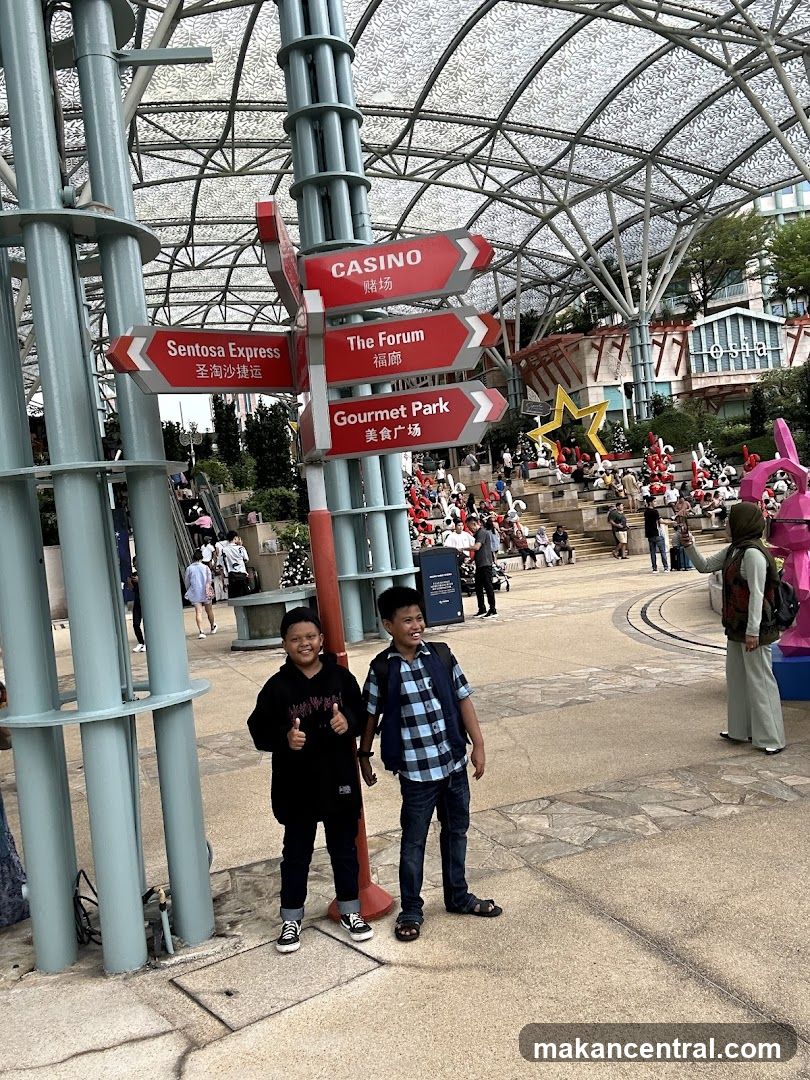 Two boys posing in front of a directional sign