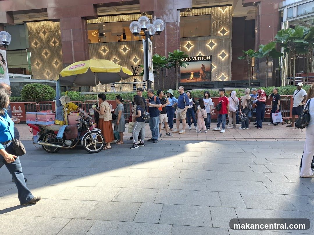 Street vendor with Louis Vuitton store in background